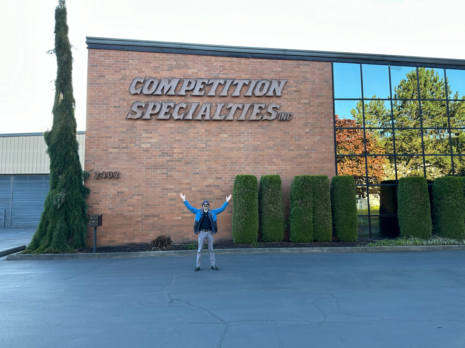 Competition Specialties headquarters with storefront signage and a team member standing outside